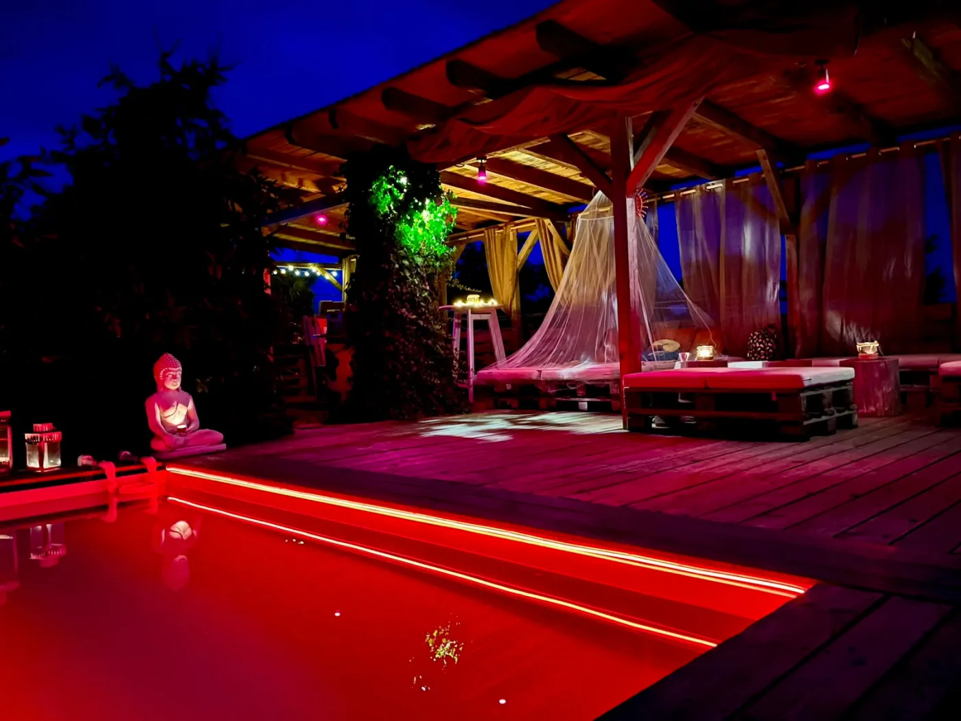 Beleuchteter Pool und Lounge im Garten Eden bei Nacht
